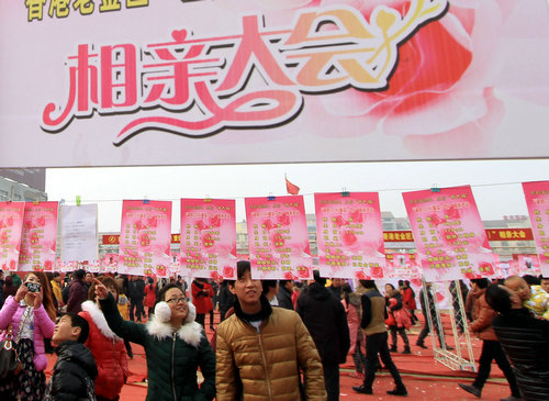 資料圖片：2014年2月15日，男女青年在河南省溫縣舉行的相親大會活動現場閱讀相親資料。新華社發