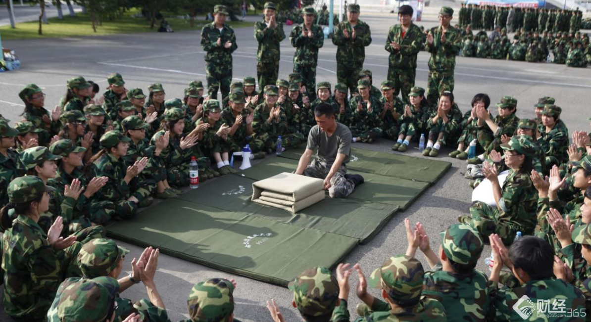 軍隊教官給軍訓學生示范疊被子技巧。