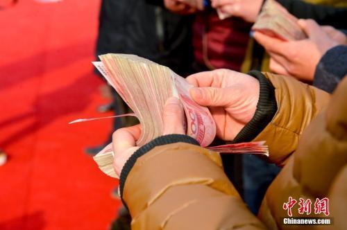 領到錢的農民工正在清點工資。 圖片來源：視覺中國